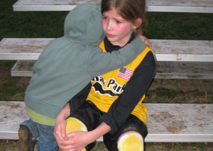 młodszy brat przytula płaczącą siostrę